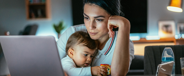 Mother Using Laptop with Infant in her lap.