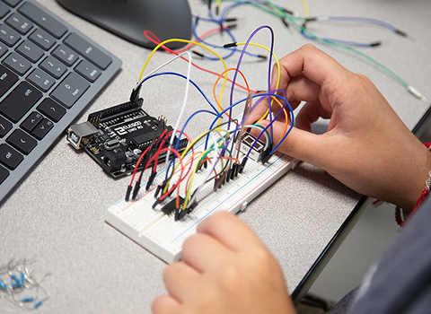 a person holding electronic engineering-related items.