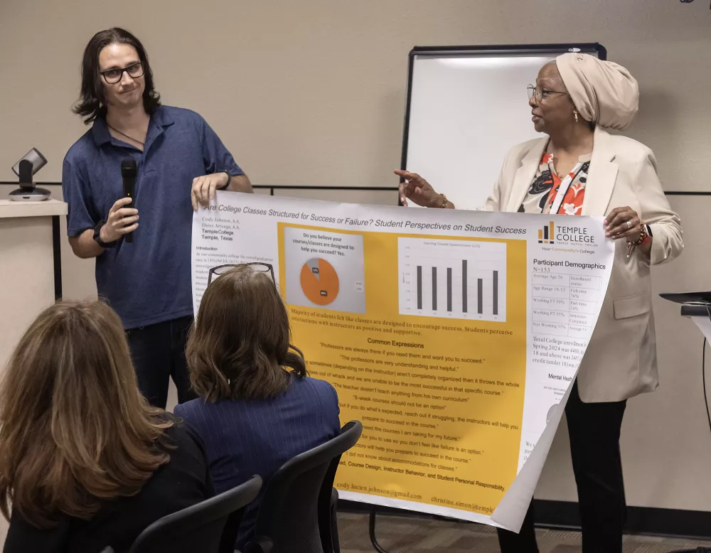 Graduate and Professor present research poster