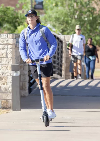 Student riding scooter