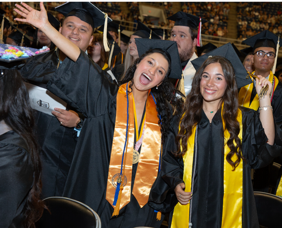 2 Temple College 2026 graduates with arms in the air in celebration